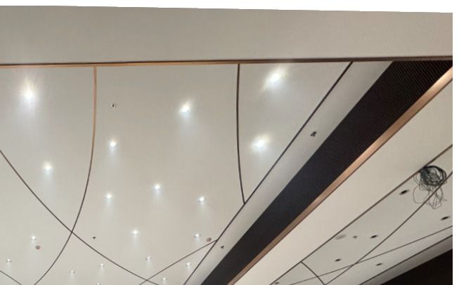 Photo of the finished curved ceiling with recessed lighting and stainless steel edge trim